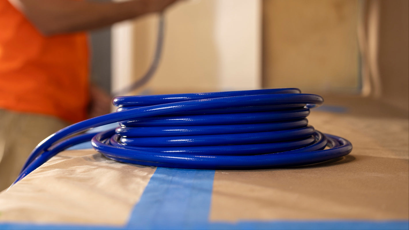 Person holding a blue hose with a blurred background